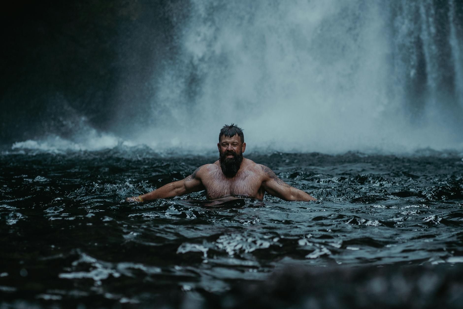 man during refreshing bath in wild river