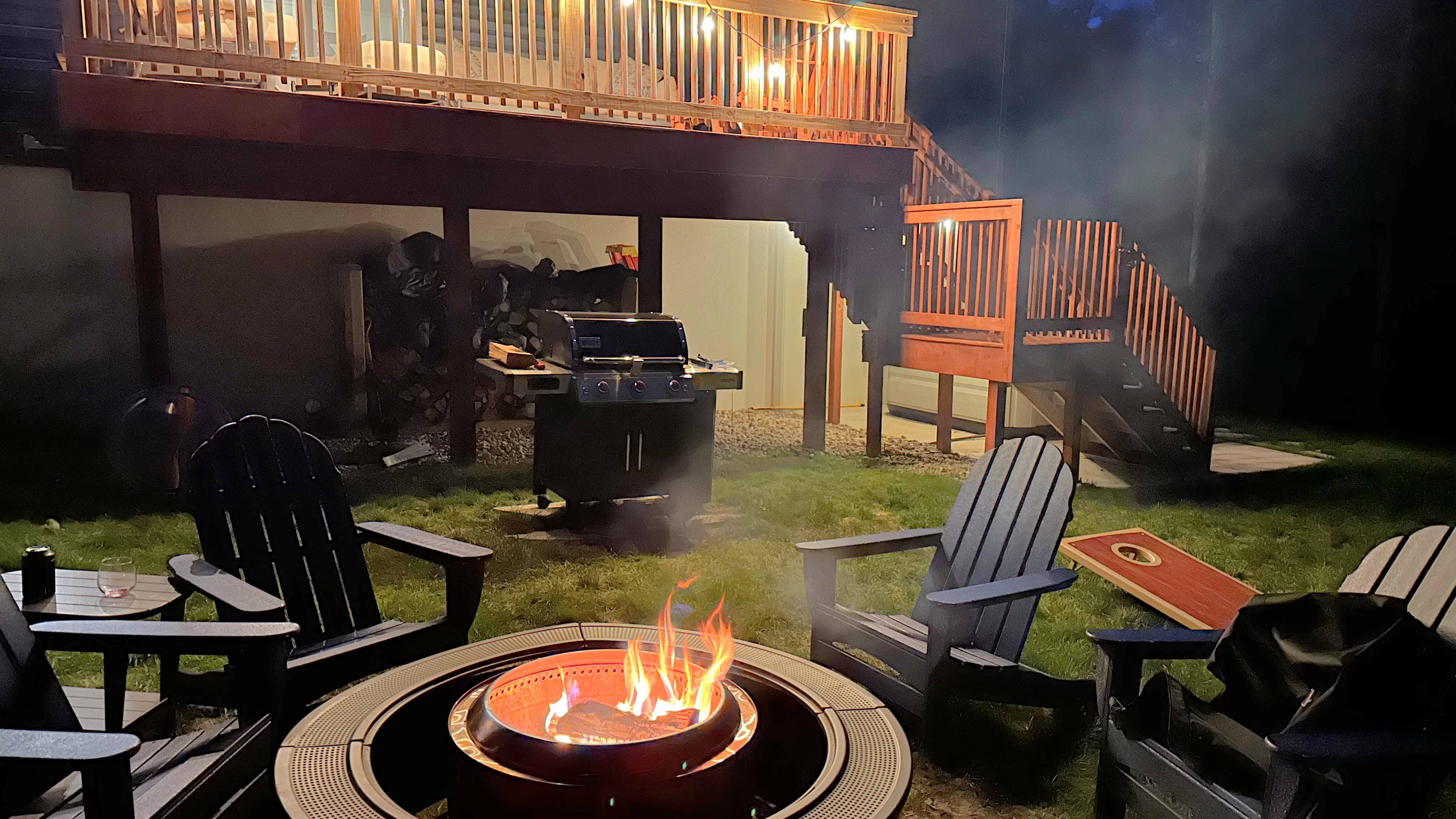 Outdoor fire pit and Adirondack chairs at The Bird House vacation rental near Harbor Springs, Michigan at night