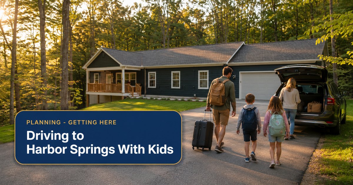 A family with backpacks and a rolling suitcase walking up the driveway to The Bird House, a navy house in the woods near Harbor Springs, Michigan, after the drive Up North